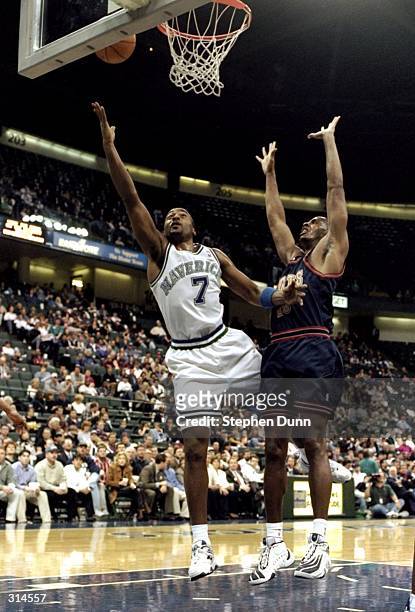 Guard Dennis Scott of the Dallas Mavericks and forward LaPhonso Ellis of the Denver Nuggets fight for the ball during a game at the Reunion Arena in...