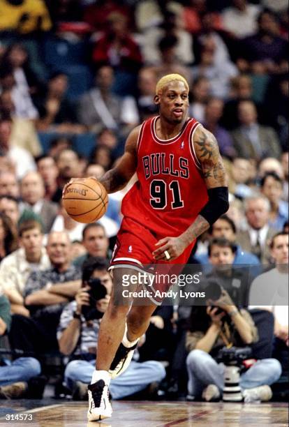 Forward Dennis Rodman of the Chicago Bulls moves the ball during a game against the Miami Heat at the Miami Arena in Miami, Florida. The Heat won the...