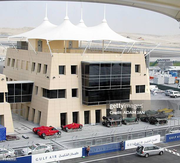 Formula One cars are parked next to the race control tower 27 March 2004 as preparations get underway at the race track where the Bahrain Grand Prix...