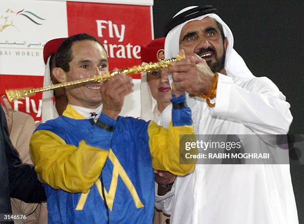 The Crown Prince of Dubai and UAE Defense Minister Sheikh Mohammed bin Rashed al-Maktoum raises the trophy with US jockey Alex Solis after he won the...