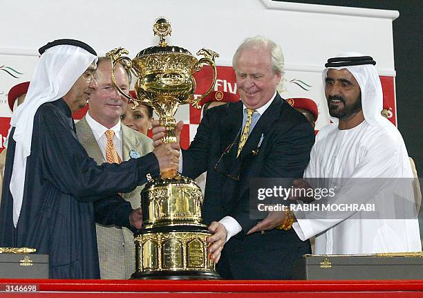 Trainer Richard Mandella and Gerald Ford , the American owner of winner Pleasantly Perfect, receive the Dubai World Cup from the ruler of Dubai...