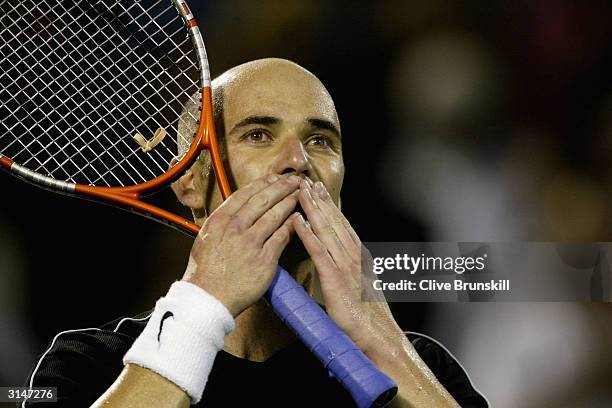 Andre Agassi of the USA blows a kiss to the crowd after his straight sets victory over Mariano Zabaleta during the second round on March 27, 2004 at...