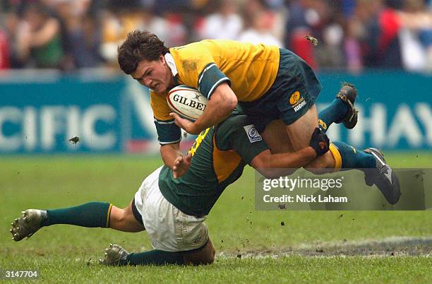 Adam Ashley Cooper of Australia is tackled by Jaco van Schalkwyk of South Africa during the Hong Kong World Sevens day three match at Hong Kong...