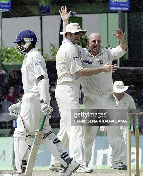 Australian cricketer Darren Lehmann and team-mate Michael Kasprowicz celebrate the dismissal of Sri Lankan batsman Mahela Jayawardene for 37 runs...