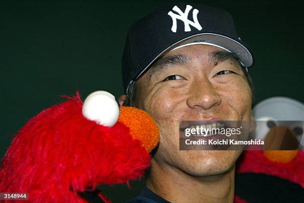 New York Yankees outfielder Hideki Matsui answers questions for a television interview with characters from Sesame Street before an exhibition game...