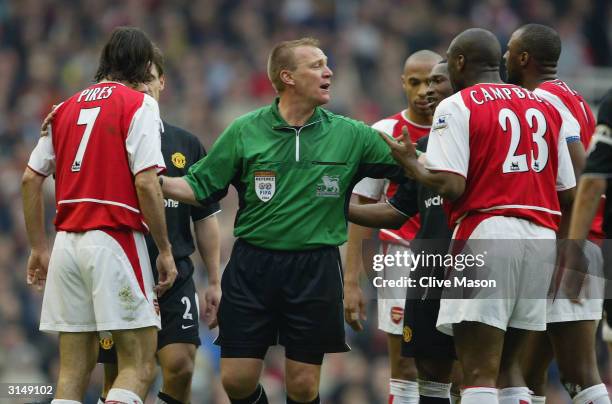 Referee Graham Poll holds apart Arsenal and Manchester United players during the FA Barclaycard Premiership match between Arsenal and Manchester...
