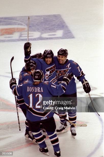Adam Oates of the Washington Capitals celebrates with teammates Joe Juneau and Peter Bondra during an Eastern Conference Finals playoff game against...