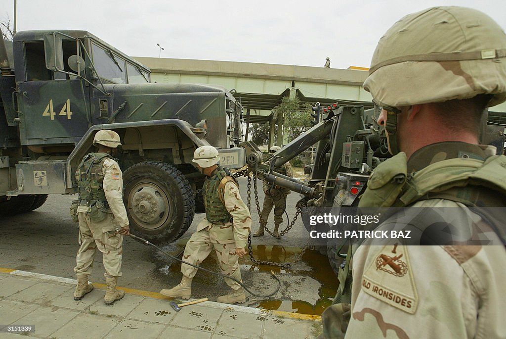 US soldiers remove a truck lightly damag