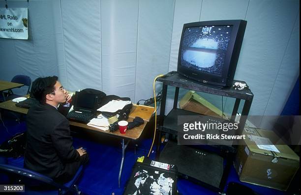 Member of the press watches the Stanley Cup Finals game between the Detroit Red Wings and the Washington Capitals from the press room at the MCI...
