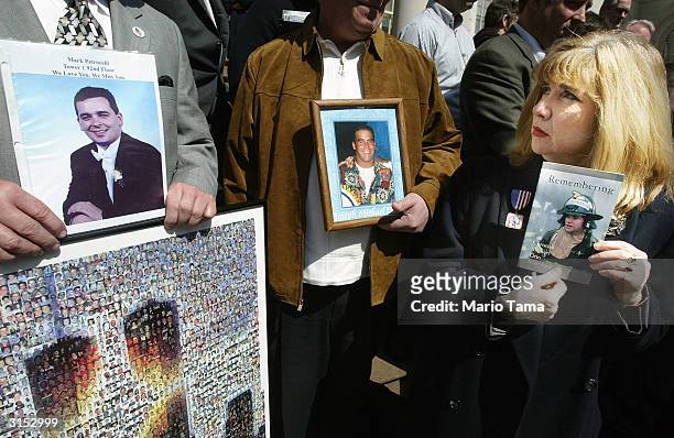Sally Regenhard holds a photograph of her son, Christian, a firefighter who died in the World Trade Center attacks, next to photos of Mark Petrocelli...