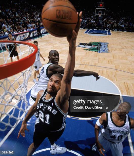 Tim Duncan of the San Antonio Spurs goes in for a layup past Kevin Garnett of the Minnesota Timberwolves during a game at Target Center on March 23,...