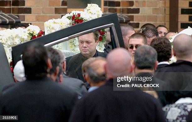 Australian underworld figure and accused drug trafficer, Carl Williams , helps load the casket of his murdered friend and bodyguard, Andrew 'Benji'...