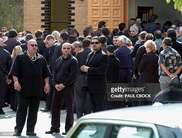 Bodyguards keep watch as mourners enter the church for the funeral of Andrew 'Benji' Veniamin, the 22nd victim of recent gangland murders, at the...
