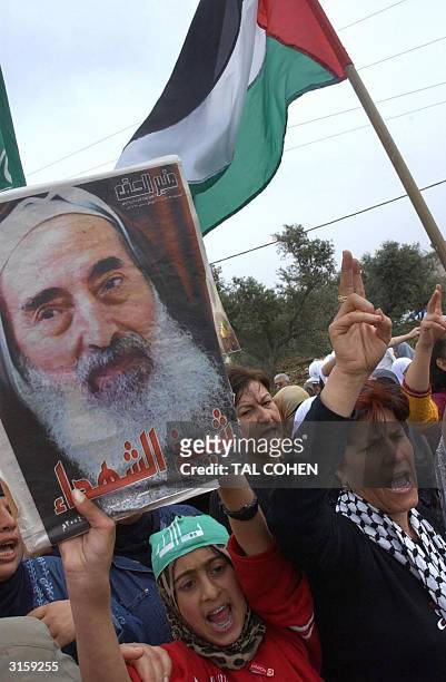 Israeli Arabs hold a poster of late Hamas founder Sheikh Ahmed Yassin in the northern Israeli village of Arraba 30 March 2004, during a demonstration...