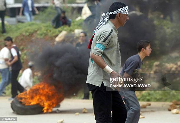 Palestinian hold stones during clashes with Israeli troops following a rally to commemorate the 28th anniversary of Land Day and against Israel's...