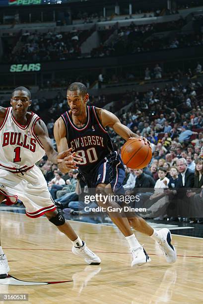 Kerry Kittles of the New Jersey Nets drives around Jamal Crawford of the Chicago Bulls during the game at the United Center on March 23, 2004 in...