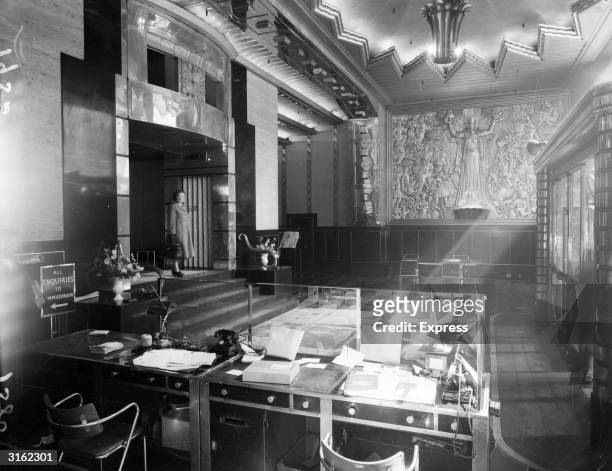 The reception desk in the front hall of the Daily Express building on London's Fleet Street. The ornate bas-relief was designed by Eric Aumonier, and...