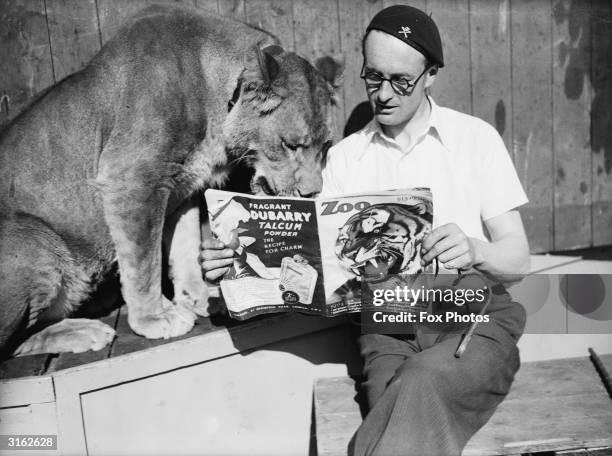 The Southend wall of death rider, Tornado Smith, reading Zoo magazine with his pet lioness.