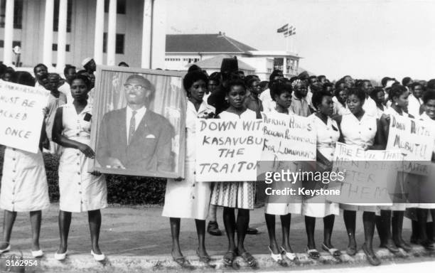 Group of women in Accra, Ghana, during a mourning parade for Patrice Lumumba, the murdered former Premier of the Congo. The slogans read 'Mobutu and...