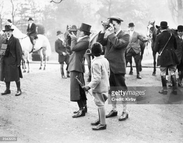 Lady Violet Astor and the Earl of Minto take a film of a meet of the West Kent foxhounds at Hever Castle.