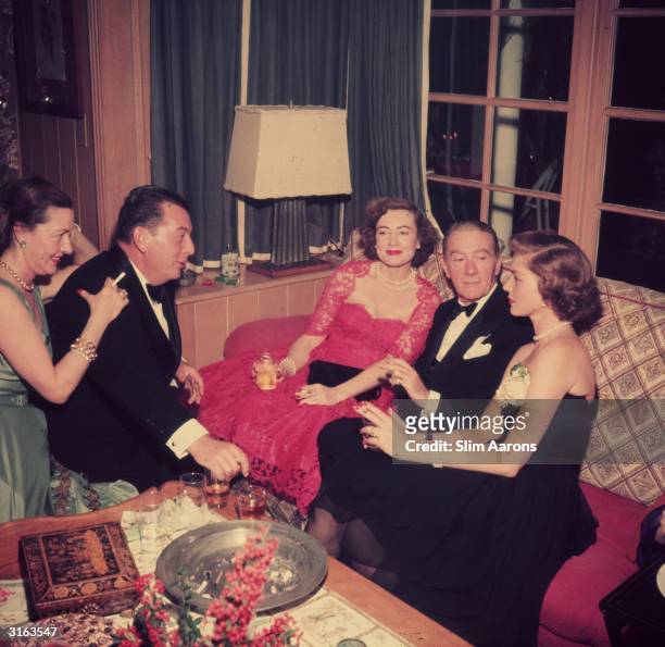 Christmas eve at the Bogart's house in Beverly Hills. From l to r; Kendall and Lewis Milestone, Mrs Oscar Levant, film star Clifton Webb and hostess...