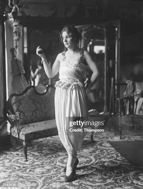 Woman modelling an evening gown with a hobble skirt, one of the latest Paris fashions on view in London.
