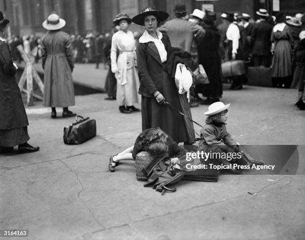 An exasperated child amongst August Bank Holiday crowds at a London railway station.