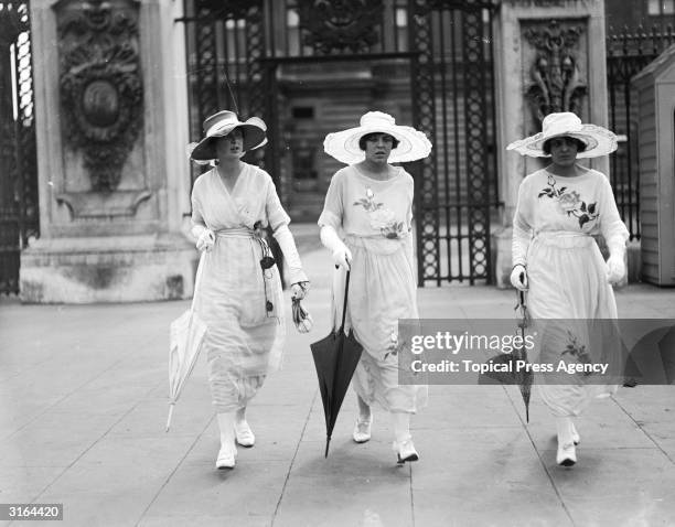 Three little maids arrive at Buckingham Palace in London for a garden party.