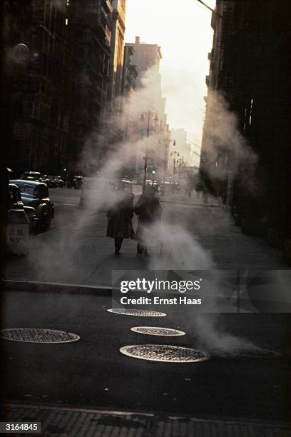 Wisps of steam drift down a New York street in the early morning.
