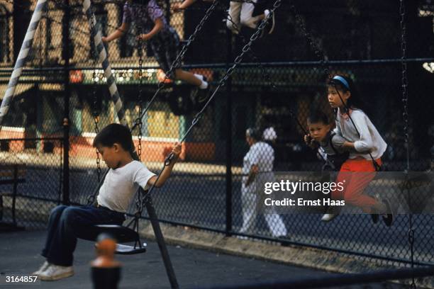 Children on swings in a New York playground.