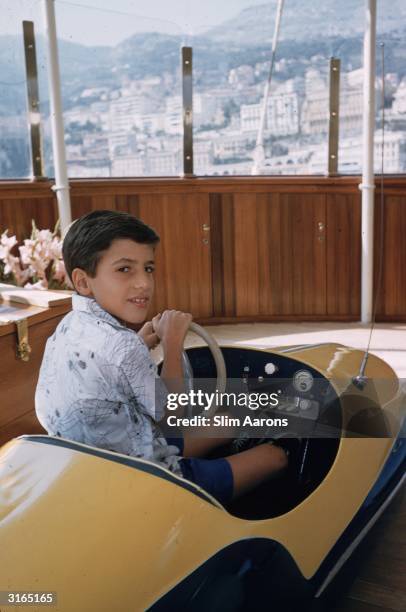 Alexander Onassis son of the Greek shipping tycoon Aristotle driving a toy car on board the family's luxury yacht 'Christina' in Monte Carlo.