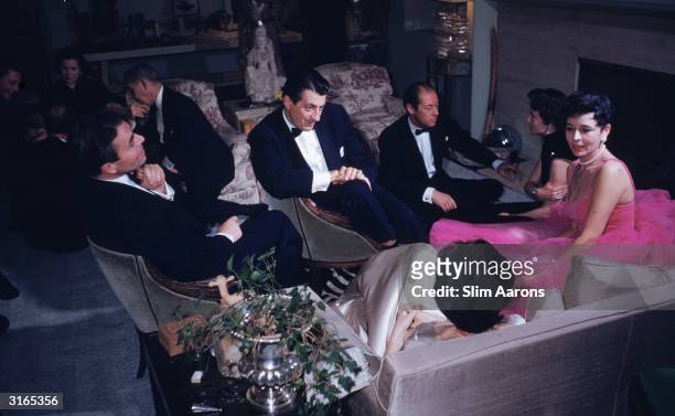 Stars chatting at a party at the Adrians' Beverly Hills home. From left to right, James Mason, Mike Romanoff, Fred de Cordova , Rex Harrison, Mrs...