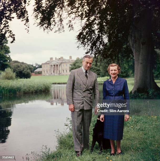 Earl Mountbatten of Burma and Lady Edwina Mountbatten walking in the grounds of Broadlands, their Hampshire home, with their dog.