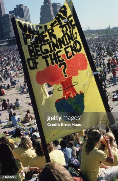 Anti-nuclear demonstrators gather in a large open space in New York . A banner they are carrying reads 'Nuclear Power The Beginning Of The End'?