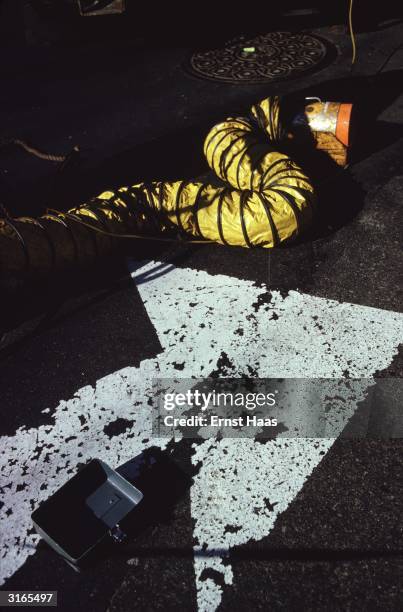 Roll of tarpaulin and road markings on a street.