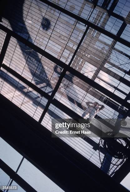 Person standing on the metal grating at the Union Carbide and Carbon chemicals plant at Institute, West Virginia.