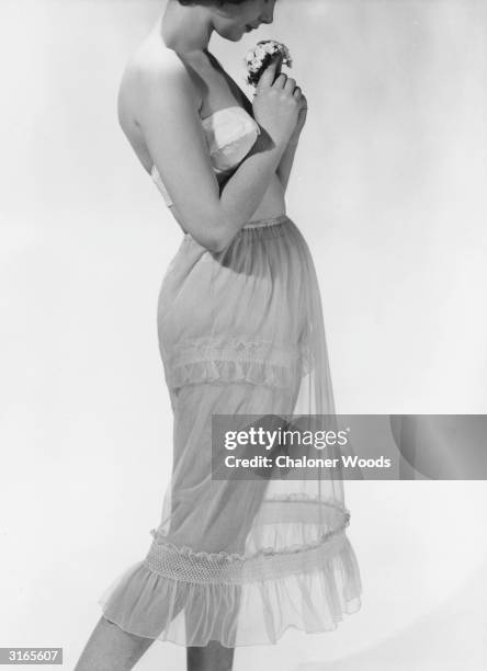 Woman modelling a lace petticoat with matching underwear.