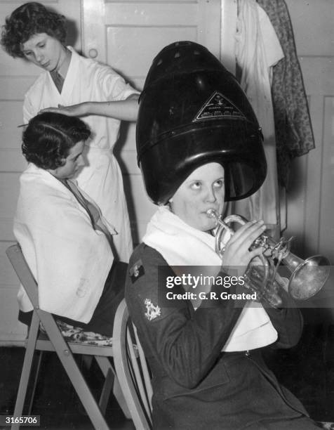 In preparation for the Coronation of Queen Elizabeth II, Private Audrey Ellis, a bandswoman in the WRAC band at Guildford, is practicing the cornet...