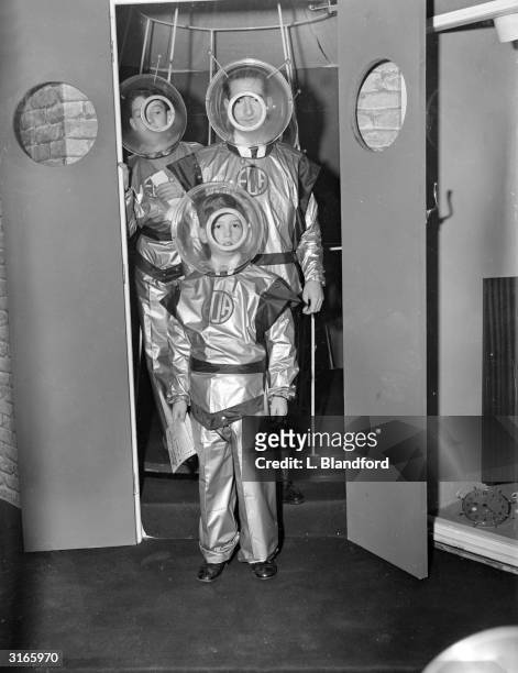 Former King Peter of Yugoslavia and his son Prince Alexander wearing space suits as they emerge from the 'Wheel Of Time' at the Schoolboys Own...