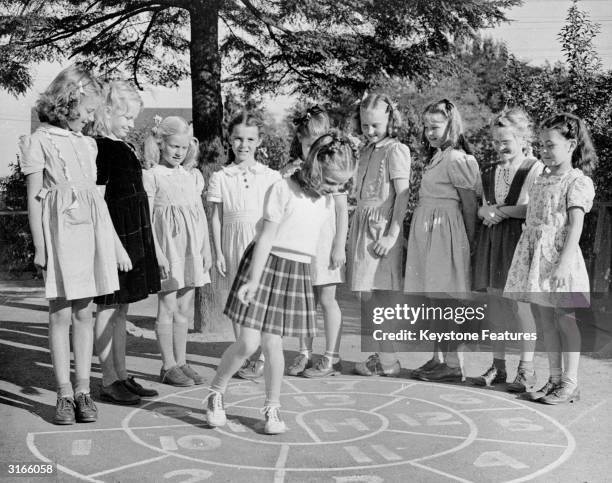 Schoolchildren from Fairview School in Seattle, Washington, play a game of hopscotch.