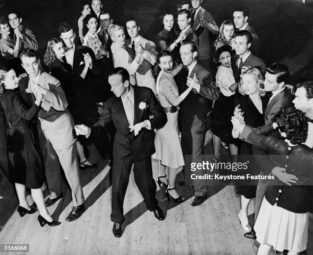 Hollywood dancer and actor Fred Astaire demonstrating steps from his new dance 'The Astaire', to dance instructors at his dance studios in the Park...