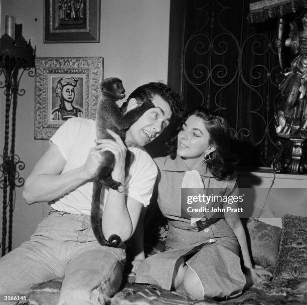 British starlet Joan Collins with her husband Maxwell Reed and their pet monkey Spider, at their Spanish-themed home in London's Mayfair.