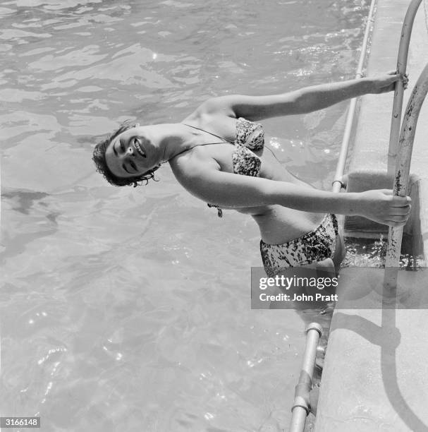 Year-old starlet Jackie Collins, the younger sister of Joan Collins, cools off at the Oasis swimming pool in London's Holborn. She later made a name...