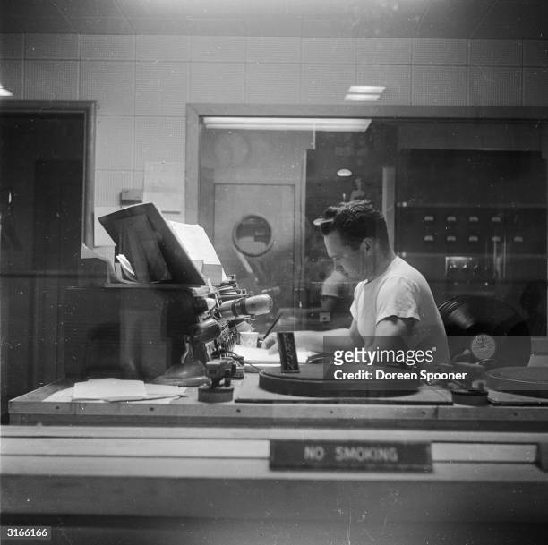 Disc jockey on the air at KRSN, the radio station of Los Alamos in New Mexico. This remote city is the site of the Los Alamos National Laboratory and...