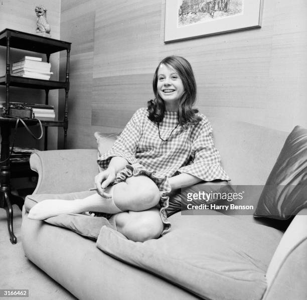 English actress Sarah Miles relaxing on her sofa at home.