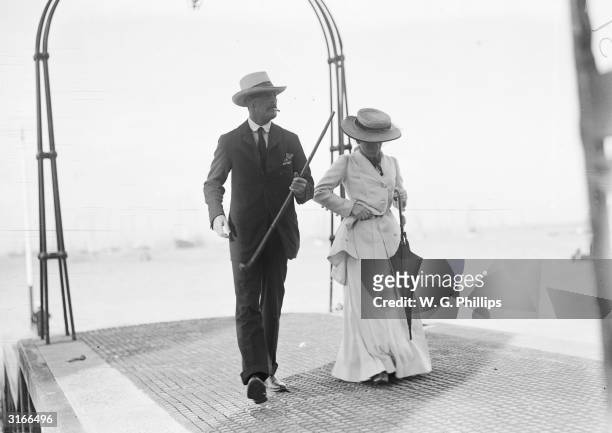 An Edwardian lady and gentleman promenade towards the shore from the end of the pier.