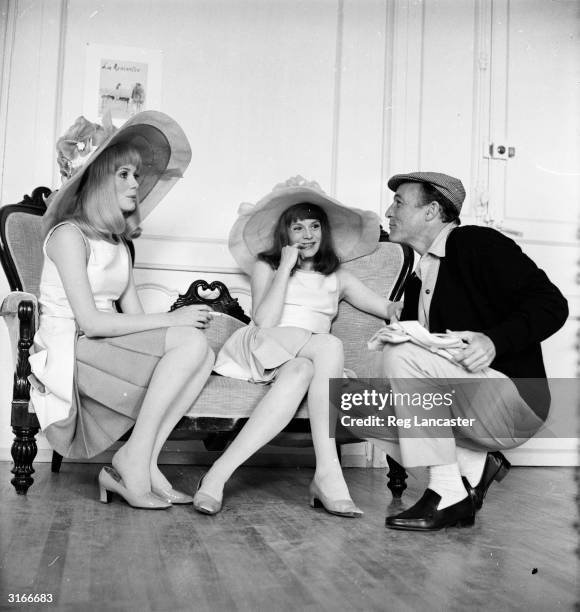 American film star Gene Kelly talking to French film actress Catherine Deneuve and her older sister Francoise Dorleac on location for the filming of...