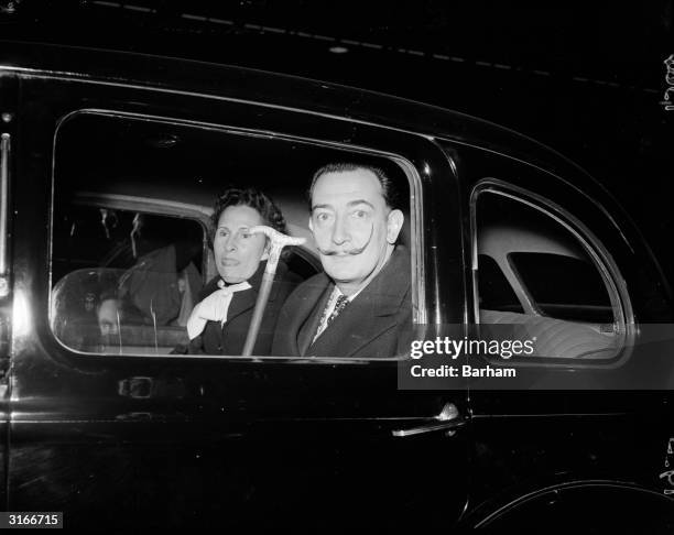 Salvador Dali and his wife Gala in a car while on a visit to London.