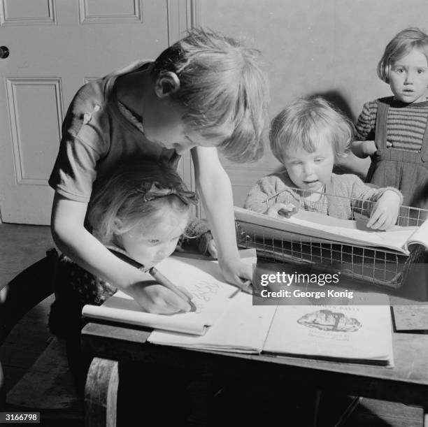 One child teaches another to draw in the nursery at 9, St Mary's Road, Peckham, south London, the new venue for the Community Centre once housed in...