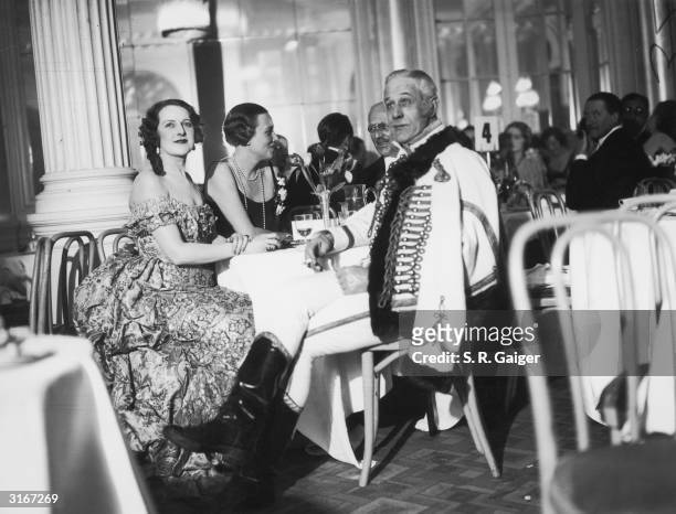From left to right, Mrs Wooley-Hart, Mrs Pryce Harrison and Mr Hugh Fraser attend the Strauss Ball at the Savoy Hotel in London. The ball, proceeds...